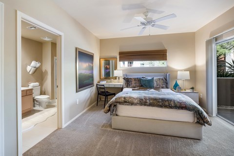 a bedroom with a bed and a bathroom with a toilet and a sink