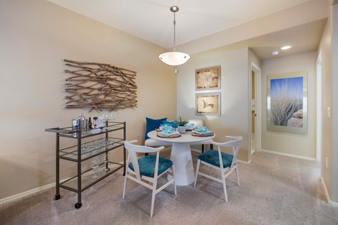 a dining area with a table and chairs and a wall art