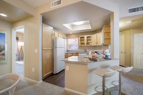 a kitchen with a bar and stools and a refrigerator