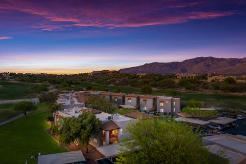 arial view of a community with buildings and a sunset in the sky