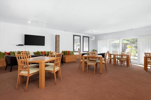 a large living room with tables and chairs and a television