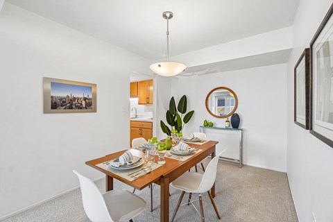 A dining room with a wooden table set for two.