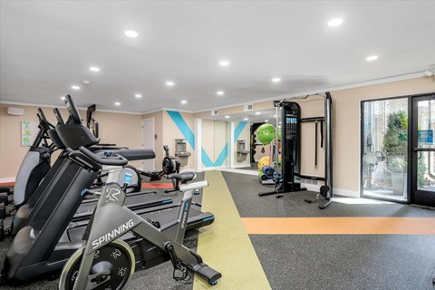 a gym with weights and exercise equipment in a room with a window