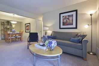 a living room with a couch and a table with a vase of flowers on it
