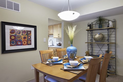 a dining room table with chairs and a blue vase