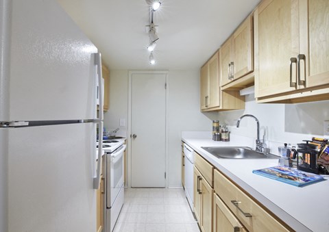 a kitchen with white appliances and wooden cabinets