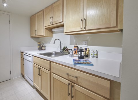 an empty kitchen with wooden cabinets and a sink