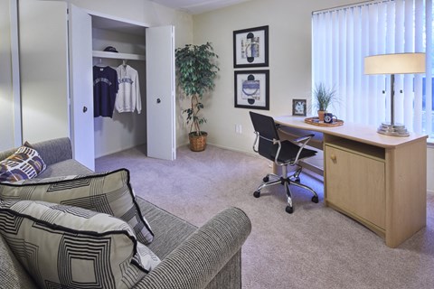 an office with a desk and a couch in a living room