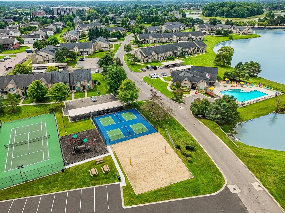 an aerial view of a neighborhood with a tennis court and a pool