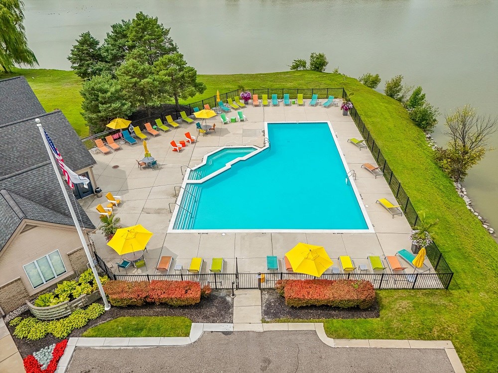 a pool is shown in a backyard with umbrellas