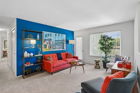 A living room with a red couch and a blue accent wall.