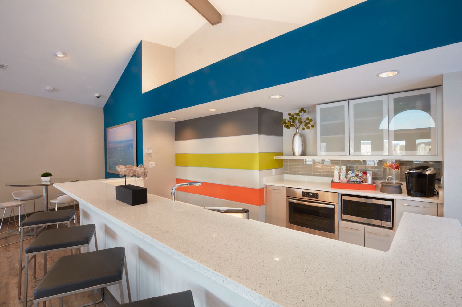 a kitchen with a long counter and a colorful wall