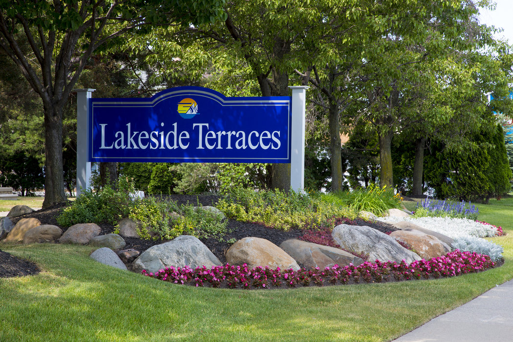 a sign for lakeside terrace in front of rocks and flowers