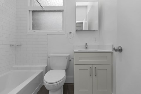 A white bathroom with a toilet, sink, and bathtub.