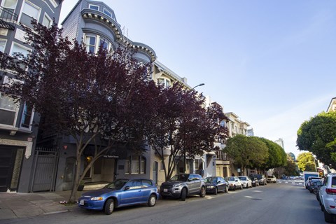 A blue car is parked on the side of a street.