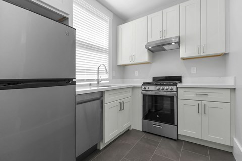 A modern kitchen with a stainless steel refrigerator and a stove top oven.