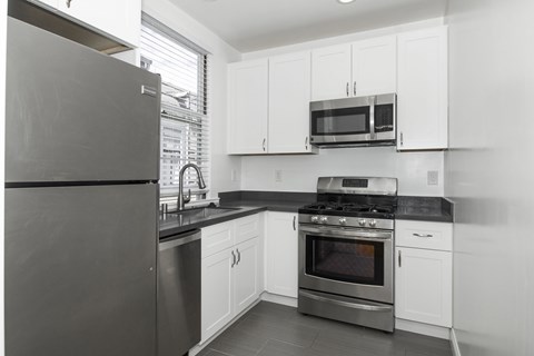 A modern kitchen with a black refrigerator and stove.