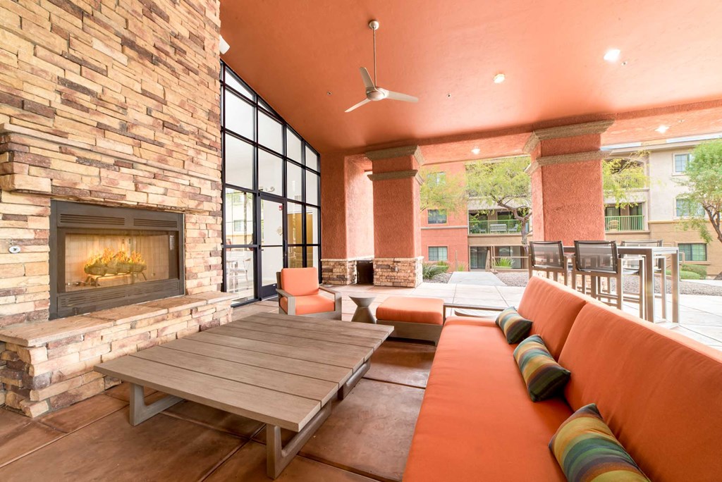 a living room with couches and a table in front of a fireplace