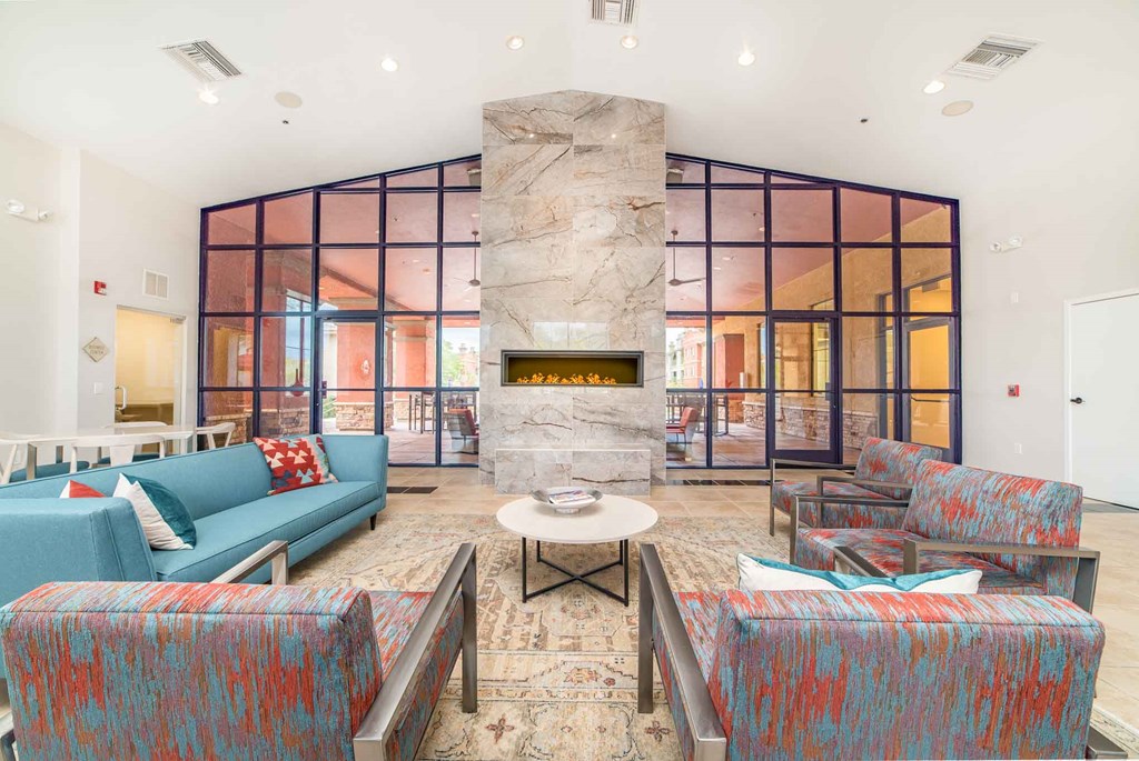 a living room with blue couches and chairs and a fireplace