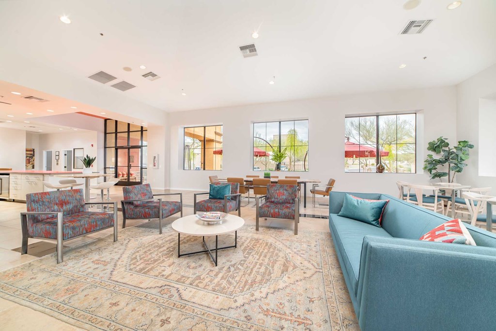 a living room with blue couches and chairs and a table