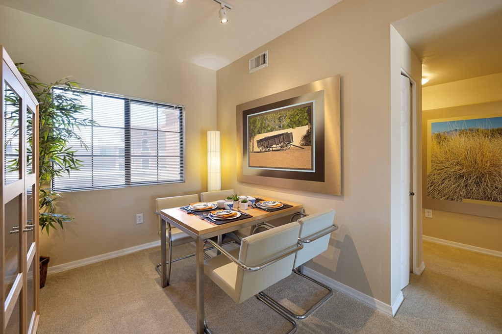 a dining room with a table and chairs and a painting on the wall