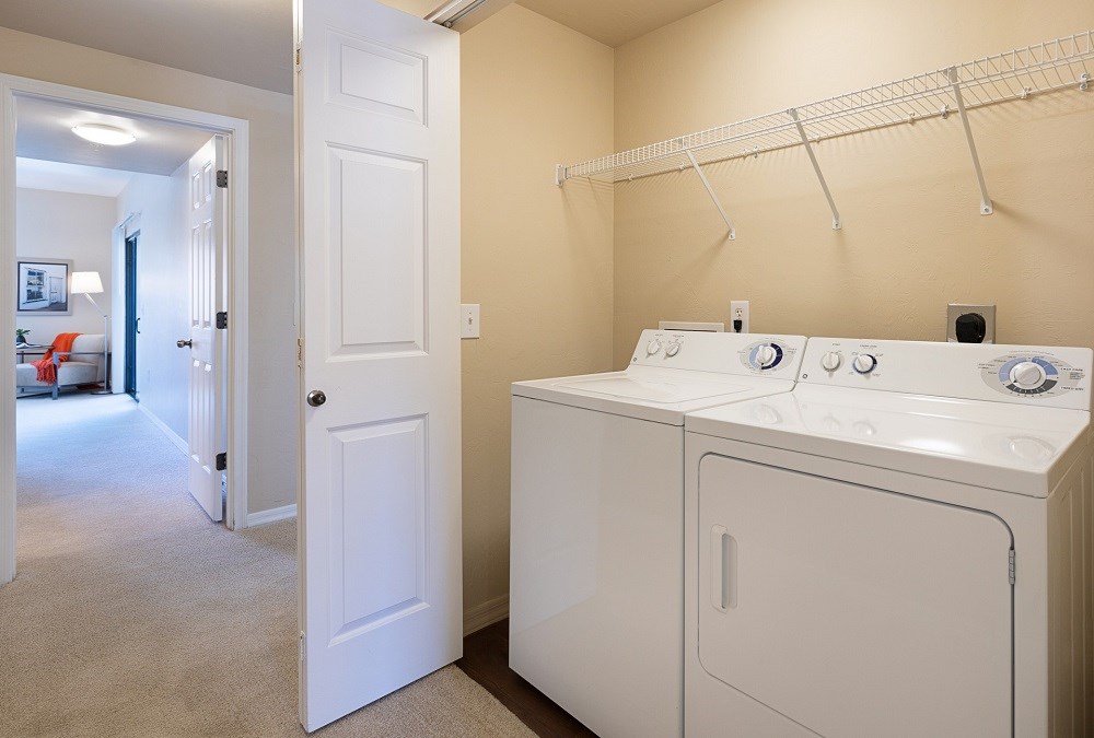a washer and dryer in a laundry room with a closet and a door