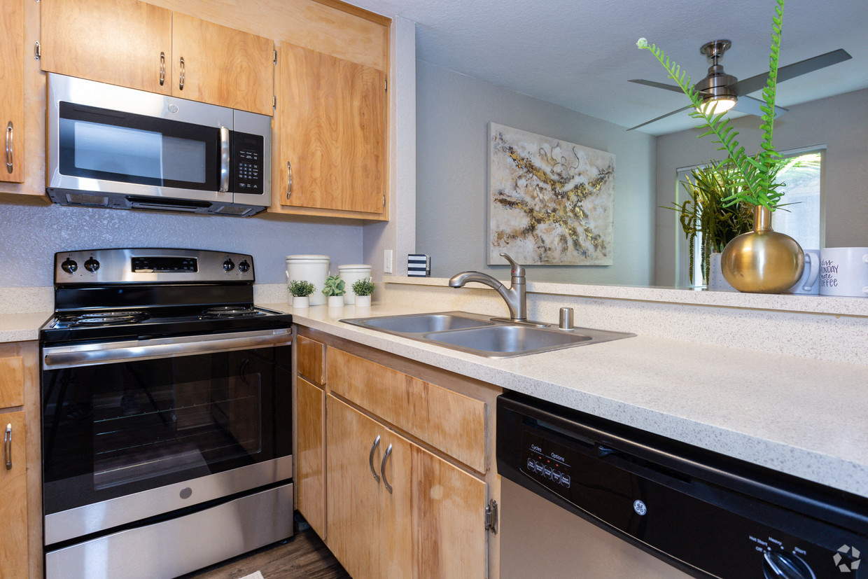 A kitchen with wooden cabinets and stainless steel appliances.