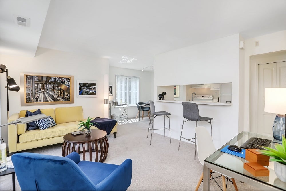 A living room with a yellow couch and blue chairs.