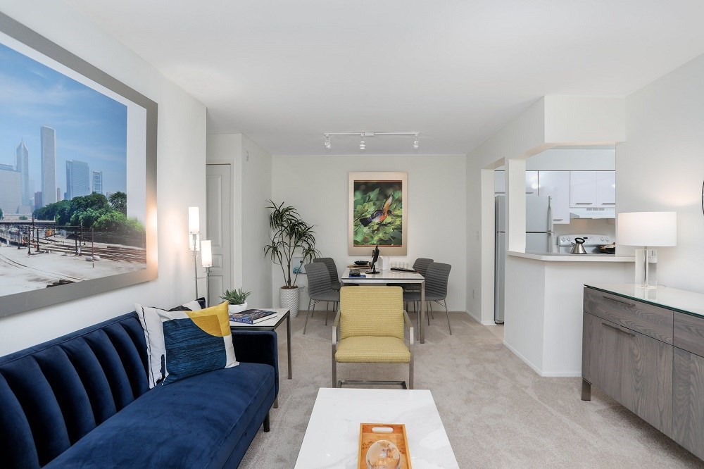 a living room with a blue couch and a table with chairs