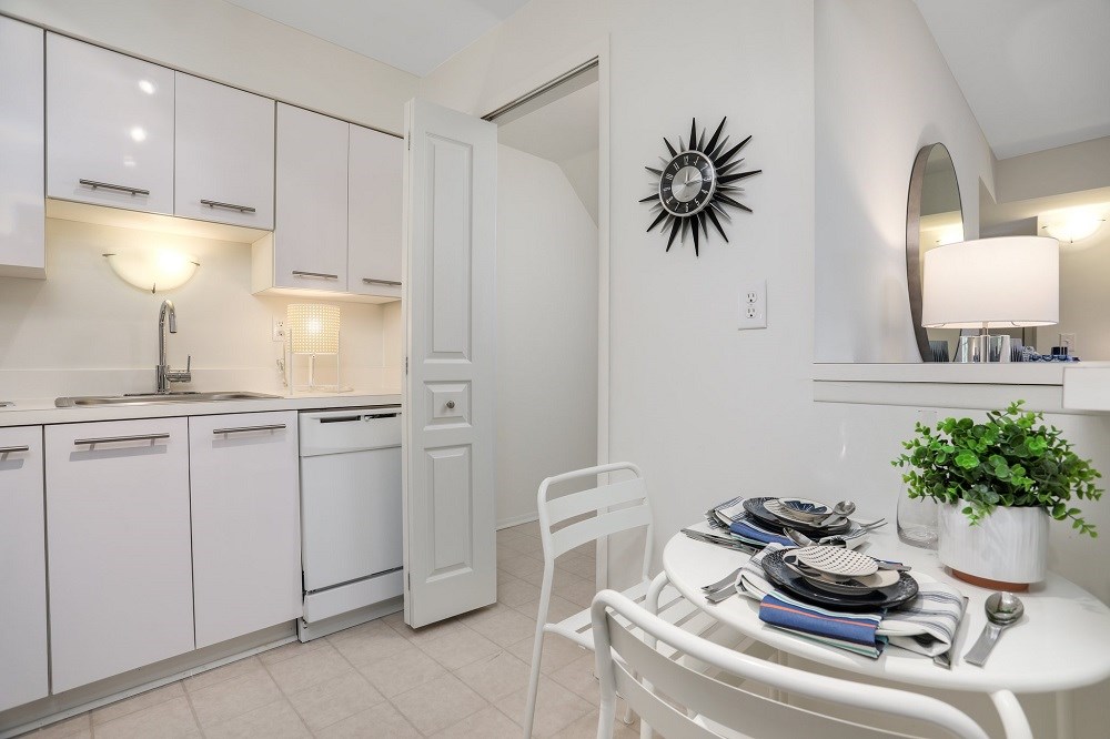 a white kitchen and dining room with a table and chairs