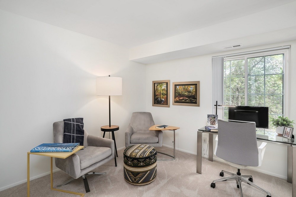 a living room with two chairs and a desk with a television
