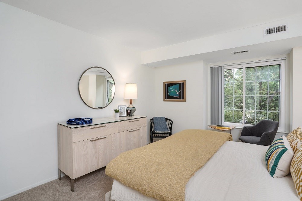 a bedroom with a bed and a dresser and a window