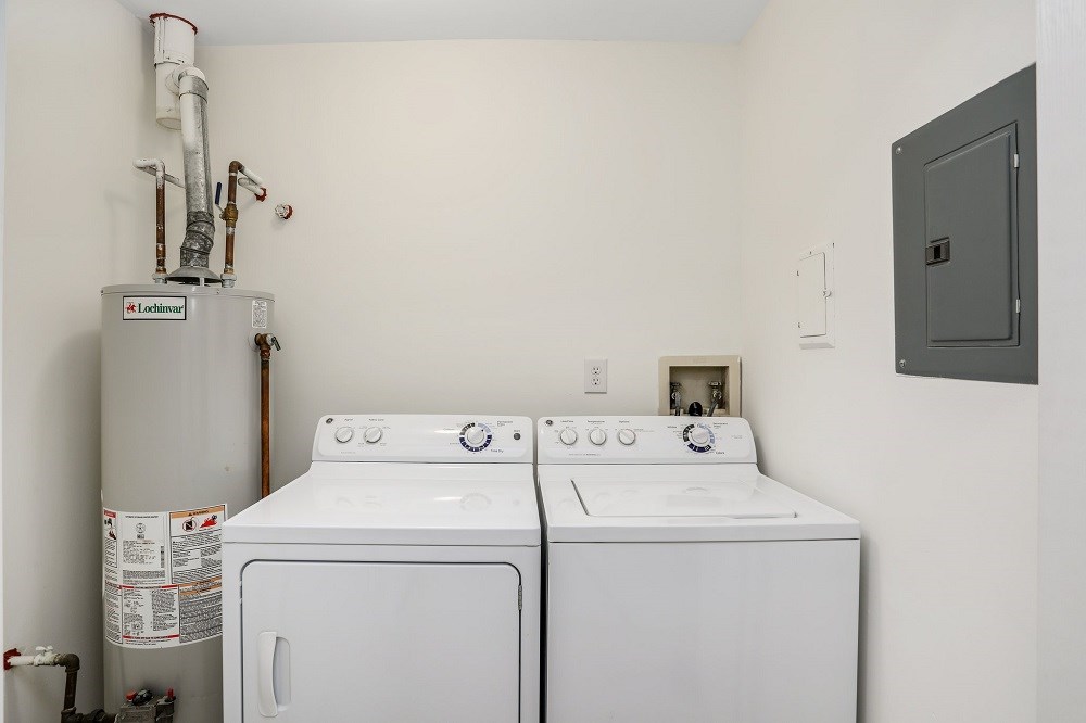 a white laundry room with two white washes and a refrigerator