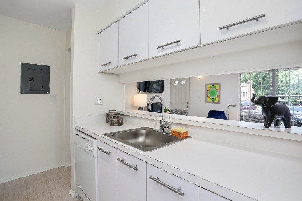 a kitchen with white cabinets and a sink and a window