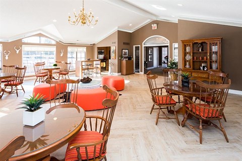 a living room with tables and chairs and a dining room