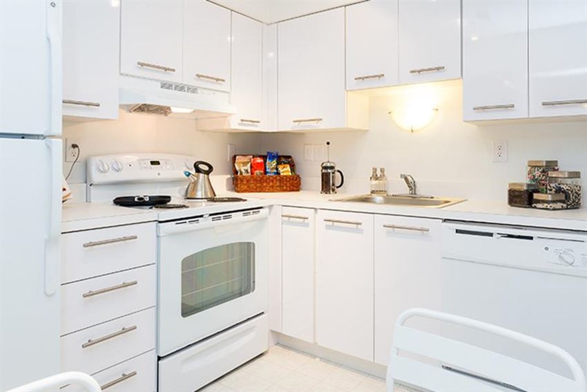 a white kitchen with white appliances and white cabinets