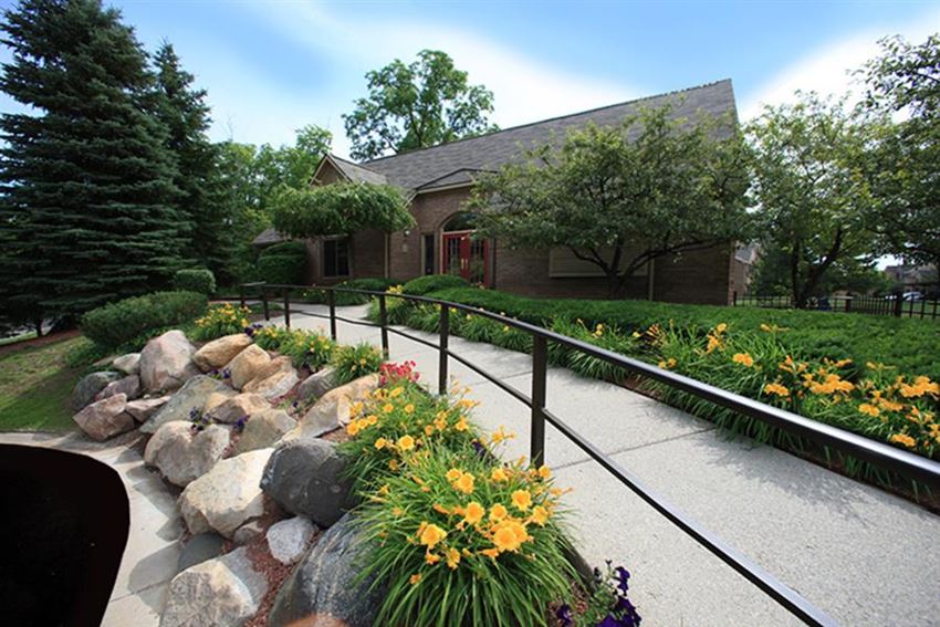 a garden with flowers and a building in the background