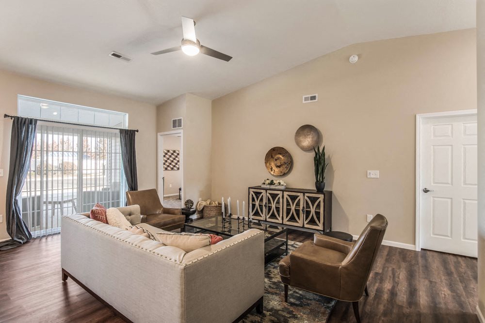 a living room with a couch and chairs in front of a window