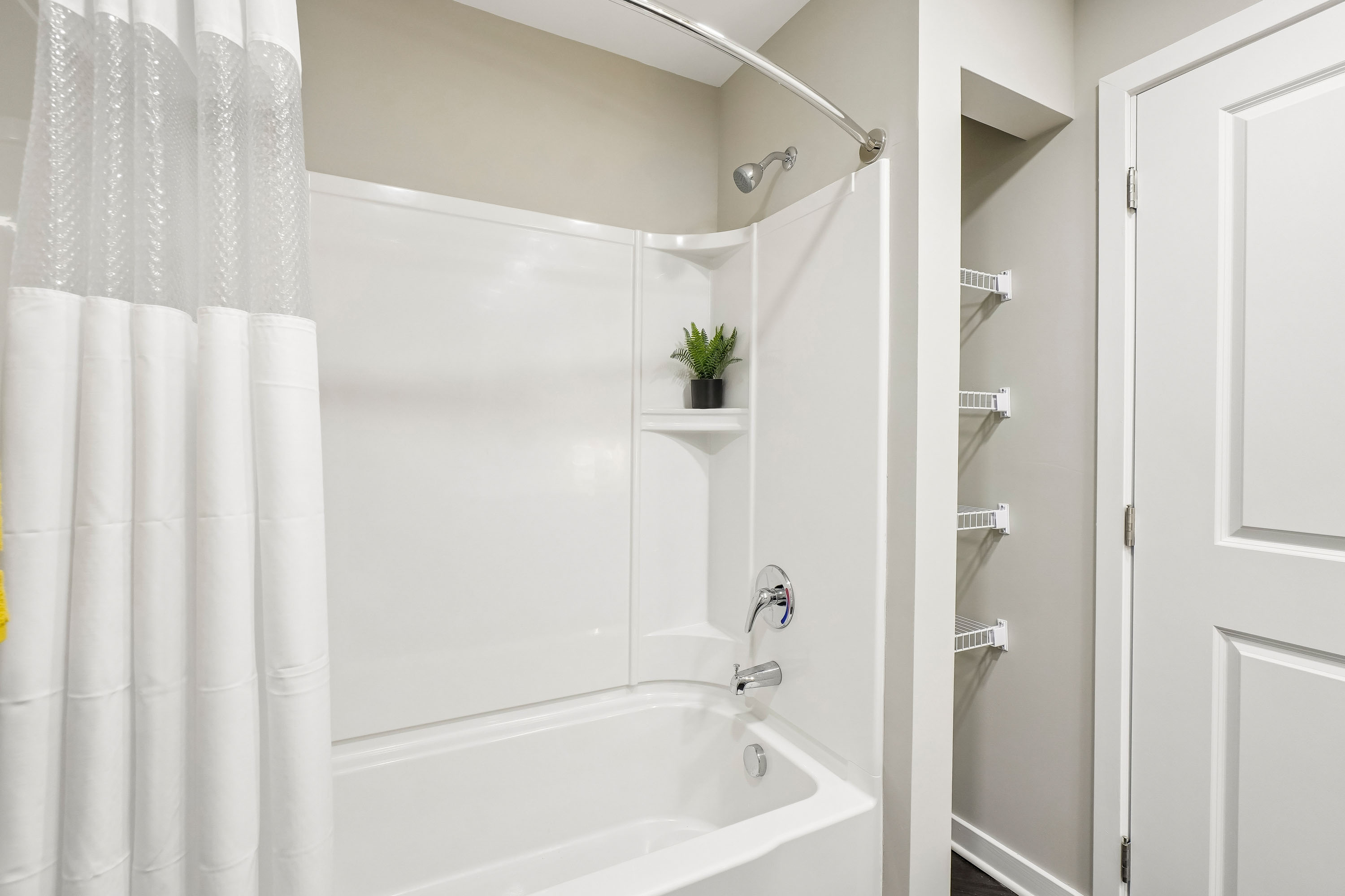 A white bathroom with a tub and a door.