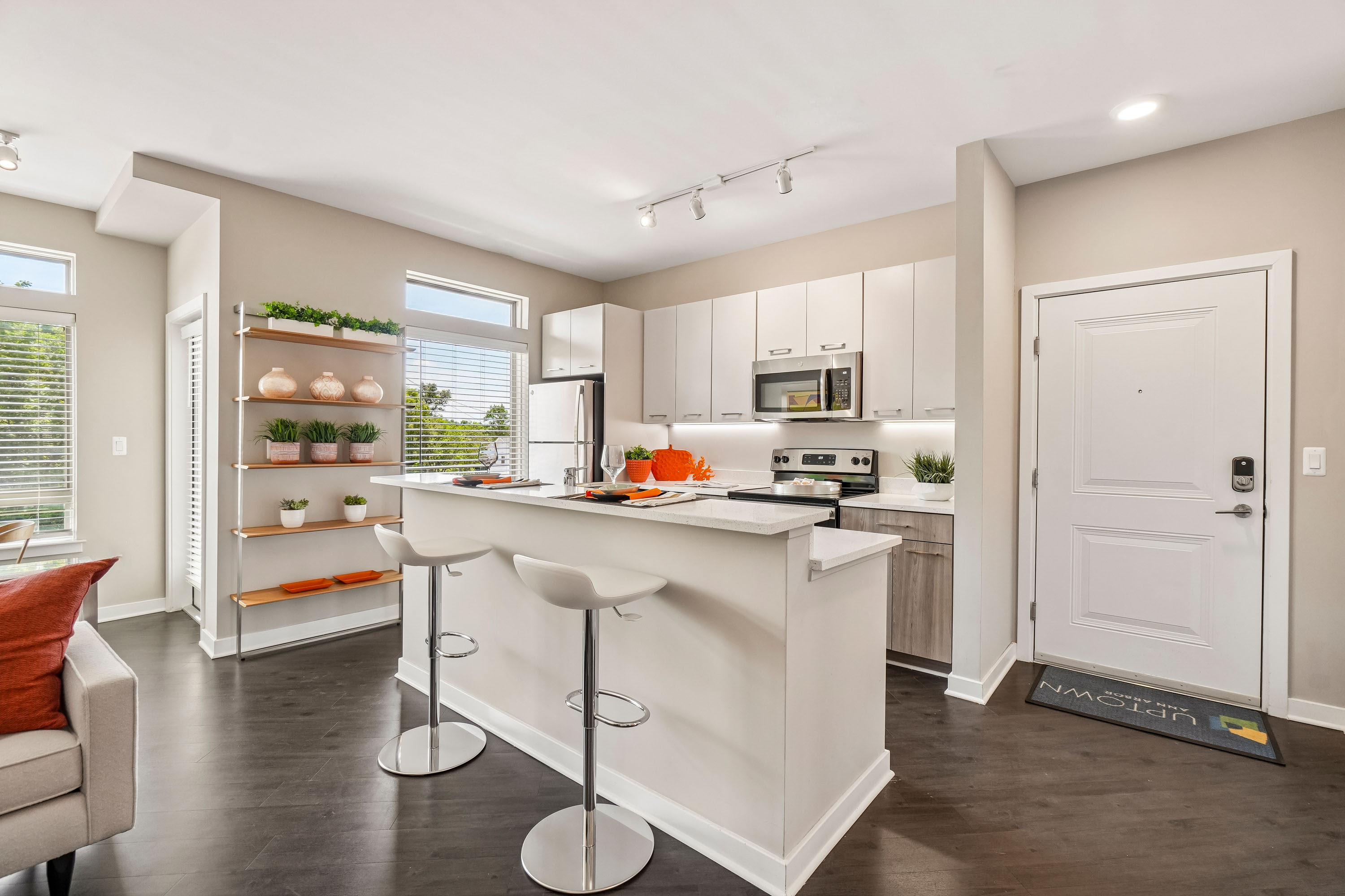 A kitchen with white cabinets and a bar area.
