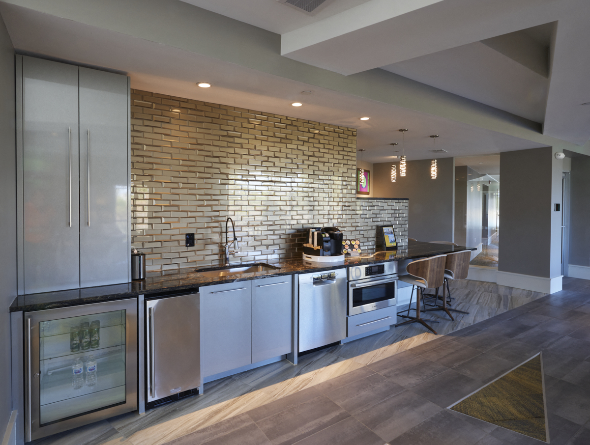 a large kitchen with stainless steel appliances and a brick wall
