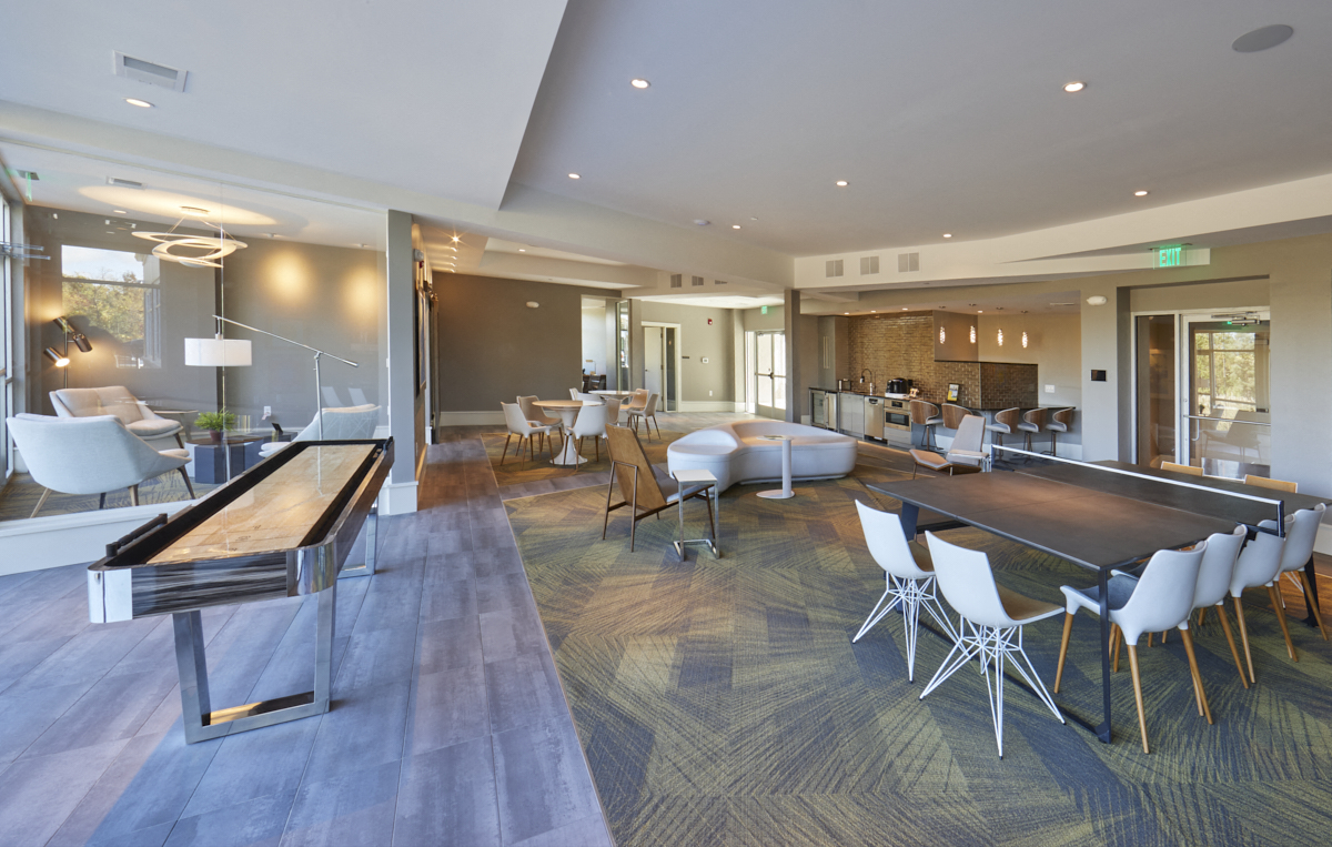 a large living room with tables and chairs and a bar