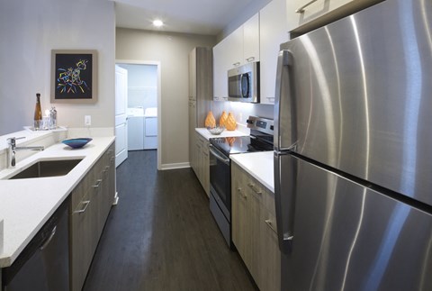 a kitchen with stainless steel appliances and white counter tops