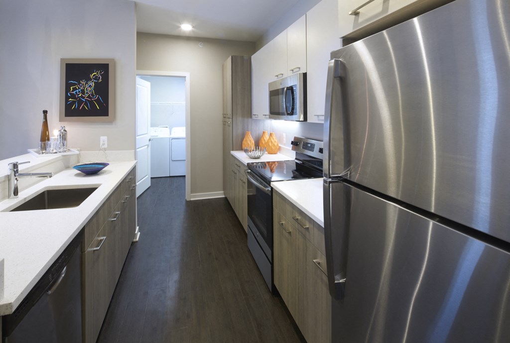 a kitchen with stainless steel appliances and white counter tops