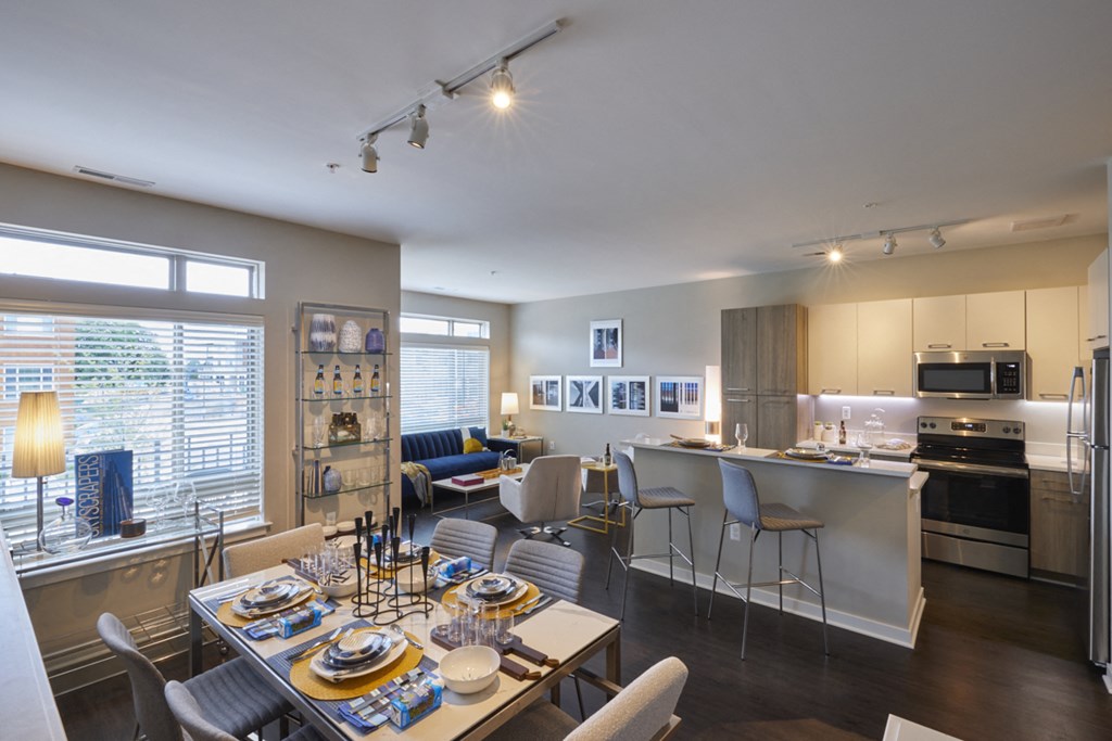 a living room and kitchen with a dining room table and chairs