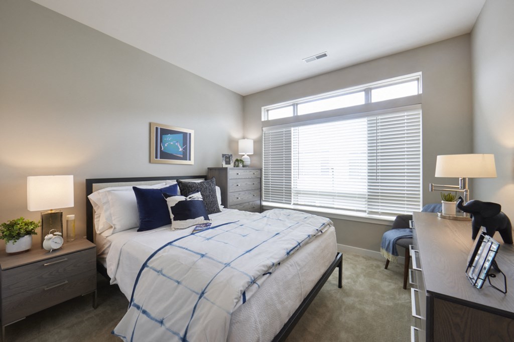 a bedroom with a bed and a desk and a window