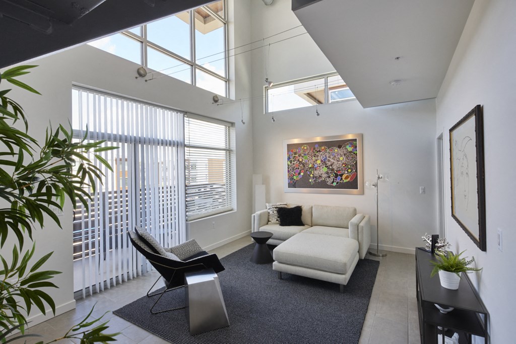 a living room with a couch and a chair and a large window