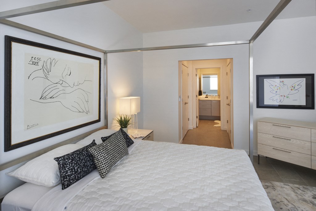 a bedroom with a large bed and a painting on the wall