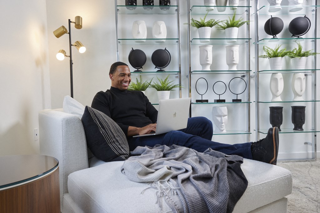 a man sitting on a couch with a laptop computer