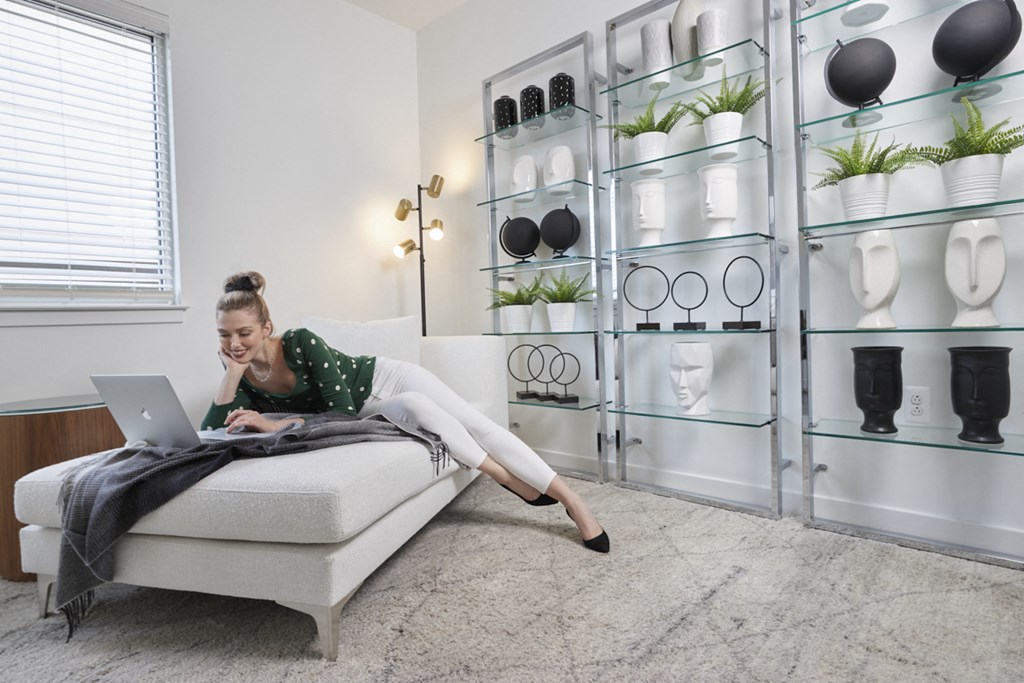 a woman sitting on a couch using a laptop computer